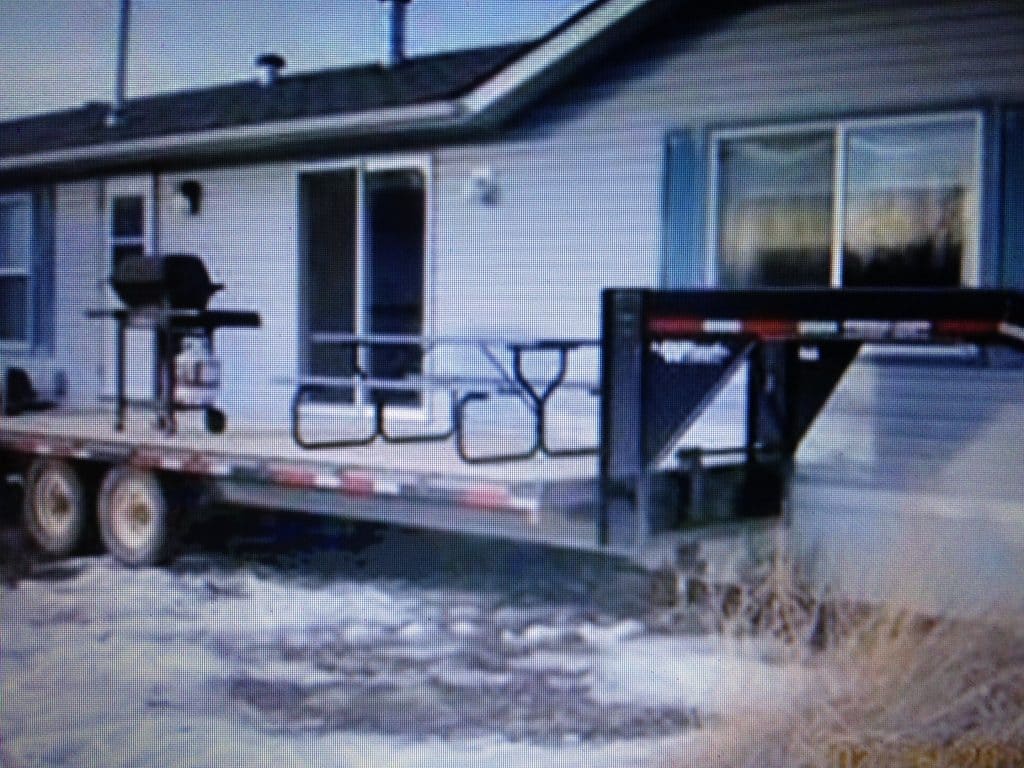 flatbed trailer next to mobile home